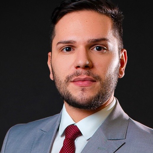 Retrato profissional de Leonardo Tavares, advogado fundador do escritório, vestindo terno escuro elegante, em ambiente de escritório moderno com estantes de livros jurídicos ao fundo, expressão confiante e profissional, iluminação suave e professional